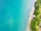 Aerial view of wooden pier leading to the sand lake with clear water. Lake with transparent water and popular tourist