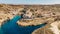 Aerial view of Xlendi, a picturesque village in Gozo island, Malta, surrounded by steep cliffs and valleys.Xlendi Bay is popular