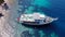 Aerial view of yacht in blue sea anchored near island with sand coast and turquoise water. Touristic excursion boat ship