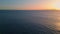 Aerial view yacht sailing to sunset horizon. Evening sundown reflecting at ocean