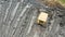 Aerial view of yellow bulldozer leveling the ground on a construction site. Heavy grader rakes soil. Drone view of preparation sur