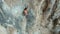 Aerial view of Young fit woman lead rock climbing on sport route on vertical cliff, outdoors rock climbing, cinematic