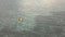 Aerial view of a young kayaker paddling a yellow boat in the calm ocean.