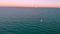Aerial view young man kite surfing in mediterranean sea at sunset. Kite surf