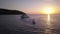 Aerial view of young people riding sea scooter near yacht in clear azure water