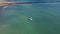 Aerial view of a young woman practicing stand up paddle surfing kneeling on the board