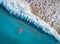 Aerial view of young woman swimming on the pink swim ring