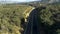 Aerial wide shot of car driving on beautiful countryside road, California