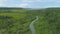 AERIAL: Wild jungle surrounds meandering tropical river flowing into the ocean