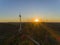 Aerial Wind farm turbines silhouette at sunset. Clean renewable energy power generating windmills.