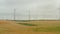 Aerial: wind turbine farm on rich yellow agriculture field rotating by the force of the wind and generating renewable