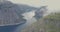 Aerial winding fjord between mountains covered with clouds