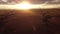 Aerial Windmills cinematic sunset flight with distant Rocky Mountains near Pincher Creek Alberta Canada