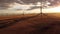 Aerial Windmills spinning cinematic shot at sunset with distant mountains.