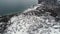 Aerial winter landscape of curvy road, snowy hills and a coastline. Shot. Top view of country road on snowy fields and