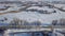 Aerial of the winter road with a bus riding along the small village covered by snow. Shot. Winter landscape with wooden