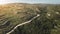 Aerial woodland and mountain ridge. Forest, trees and bushes. Blue sky, sun light. Trails on hills.