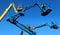 Aerial working platforms of cherry picker against blue sky