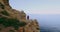 Aerial of young adventure female on cliff on ocean