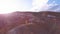 Aerial: A young girl standing in red mountain flying her kite in high mountains on background. the idea of freedom, the