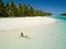 AERIAL: Young woman enjoying her vacation by sunbathing on the exotic beach.