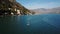 AERIAL. Young woman standing on standup paddle surfing, small town on background. Europe.