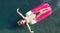 AERIAL. Young women enjoy floating on a mattress at the sea. Mountains on background.