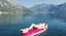 AERIAL. Young women enjoy floating on a mattress at the sea. Mountains on background.