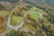 Aerial zenith view of the curves of a mountain road through oak forests.