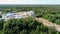 Aerial Zoom View of Small Modern Brick Factory and Warehouse in Forest in Summer