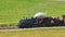 Aerial Zoomed Parallel View of a Steam Passenger Train Traveling on a Single Track