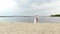 Aero, beautiful newlyweds standing on the beach, under a transparent umbrella, against the blue sky, river, and a large