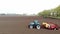 Aero. spring sunny day. On an agricultural field, a tractor with special equipment is planting potatoes. Automated