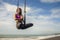 Aero yoga beach workout - young attractive and athletic woman practicing aerial yoga meditation exercise over the sea training