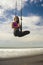 Aero yoga beach workout - young attractive and athletic woman practicing aerial yoga meditation exercise over the sea training