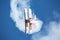 An aerobatic biplane performs a corkscrew maneuver in deep blue sky