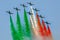 Aerobatics jet airplanes flying in formation with colorful smoke trail representing the Italian flag