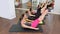 Aerobics pilates women personal trainer with pupil in a row at gym