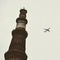 Aeroplane flying in the cloudy sky during the day time near Qutub Minar in Delhi India, Aeroplane flying high in the sky