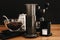 Aeropress, steel kettle, scales, manual grinder, coffee beans on wooden table and black background. Alternative coffee brewing