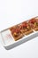 Aesthetic composition with shredded beef bruschetta on white background over white wall. Italian bruschetta with shredded beef and