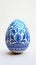 Aesthetic easter egg in traditional blue ethnic painting style. White background. Copy space. Generative AI