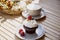 Aesthetic french berries cupcake with cappuccino among autumn decoration under sunny lights. Cozy breakfast at the