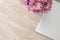 Aesthetic minimalist background for business branding, gray laptop and pink daisy flowers bouquet on neutral beige