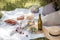 Aesthetic picnic outdoors with wine glasses bread berries and flowers. Rustic picnic with neutral tones colours.