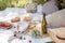 Aesthetic picnic outdoors with wine glasses bread berries and flowers. Rustic picnic with neutral tones colours.