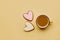 Aesthetics spring coffee and shape heart cookies. Spring card with baked glazed cookies on yellow background top view.