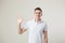 Affable guy dressed in a white t-shirt and jeans is on a white background in the studio