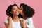 Affectionate Child. Little Black Girl Tenderly Kissing Happy Mom In Cheek