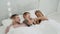 Affectionate family cute adorable funny little kid son young mom and dad lying relaxing on bed.